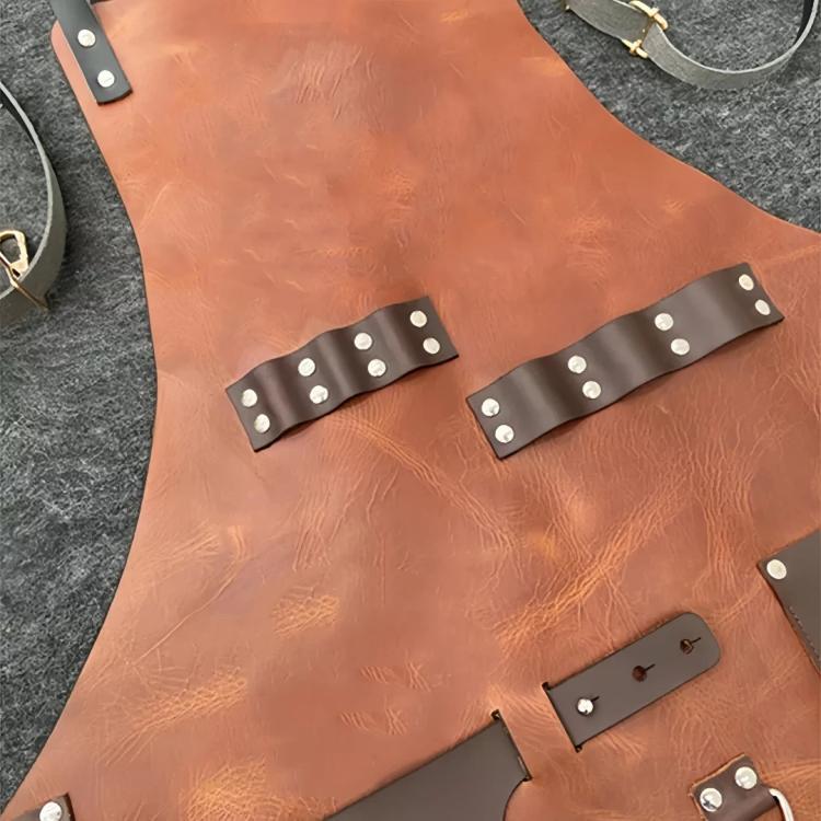 Close-up of tan waterproof BBQ apron with metal-studded leather strap accents