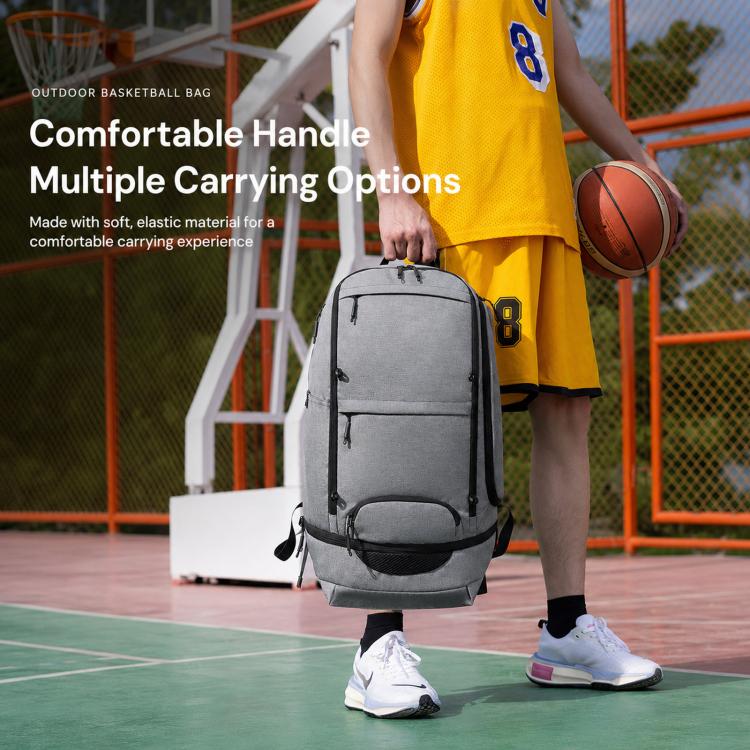 Gray basketball backpack with top handle and front zipper pocket, carried in hand