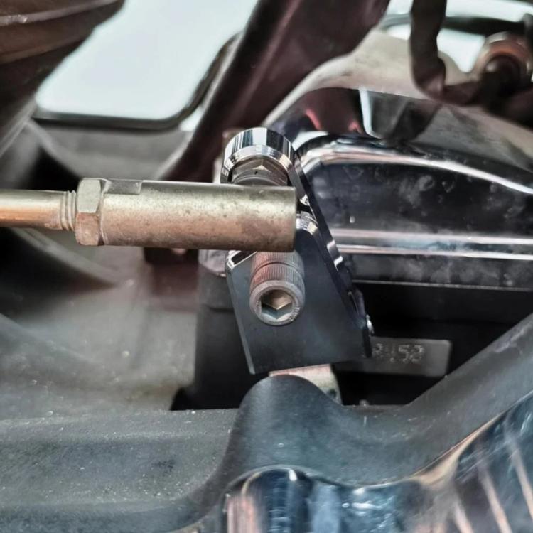 Black speed adjustment assist bracket and fasteners installed on motorcycle frame