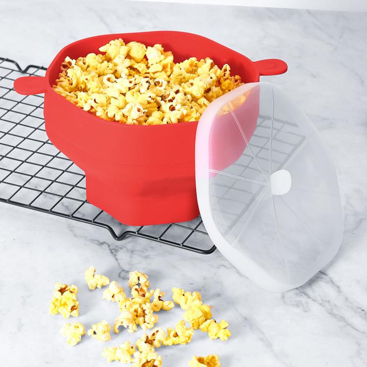 Red microwave popcorn popper bowl with clear lid on wire rack