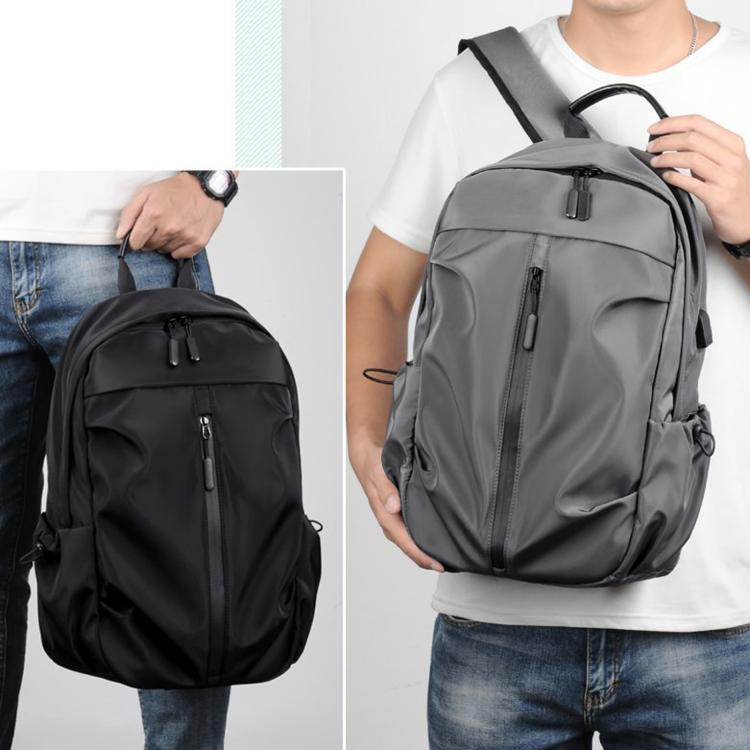 Casual laptop backpack shown in black and gray on a person, with front zipper pocket.