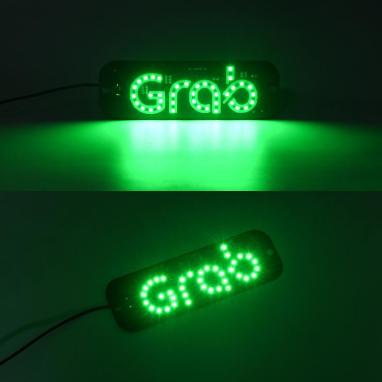 Green illuminated 'GRAB' taxi roof LED sign light in dark setting