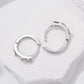 Close-up of silver-tone star and butterfly hoop earrings with clear rhinestones