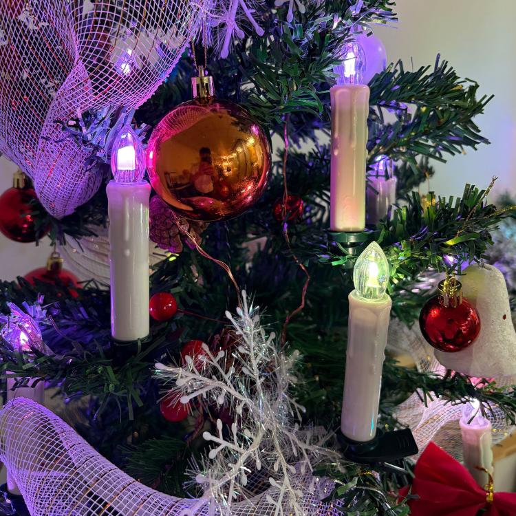 LED clip-on candle lights on a Christmas tree with warm white glow