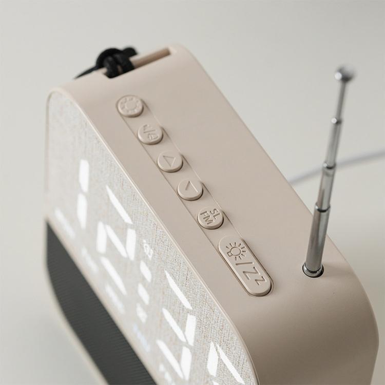 Beige digital alarm clock side view with buttons and antenna, LED display edge visible