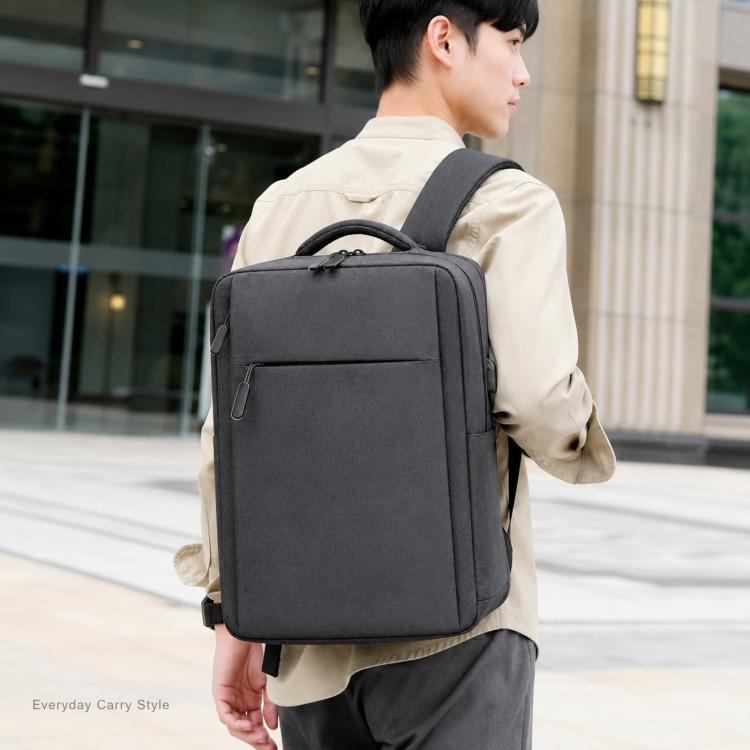 Black laptop backpack worn on shoulders with front pocket and top carry handle