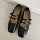 Women's vintage black flat shoes with two buckle straps and decorative perforation