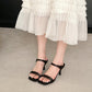 Black square-toe slide sandals with single wide strap and block high heel on foot