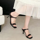Black square-toe slide sandals with one wide strap and slender block high heel on foot