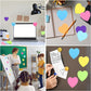Assorted heart sticky notes in bright colors on notebooks, walls, and a computer