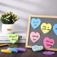 Heart-shaped sticky notes on a board, with blue, pink, yellow, and purple notes