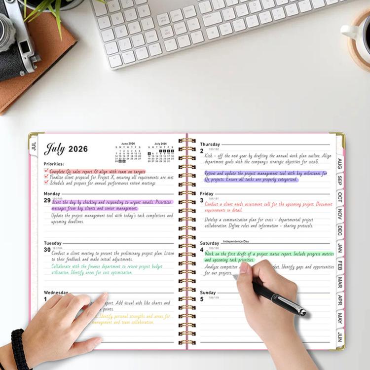 Lake blue spiral planner open to weekly pages with pen-written task notes
