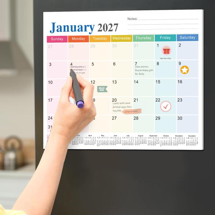 Magnetic fridge calendar pad on refrigerator, January 2027 monthly grid with notes lines.