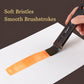 Watercolor paint brush with a soft flat bristle head painting a light orange stroke