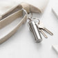 Mini sealed pill case keychain in brushed silver with metal key ring and attached keys