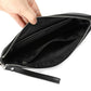 Black leather wristlet clutch bag interior with zippered opening and lined compartments.