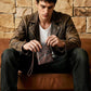 Brown leather passport holder held in hand with luggage tag and wrist strap