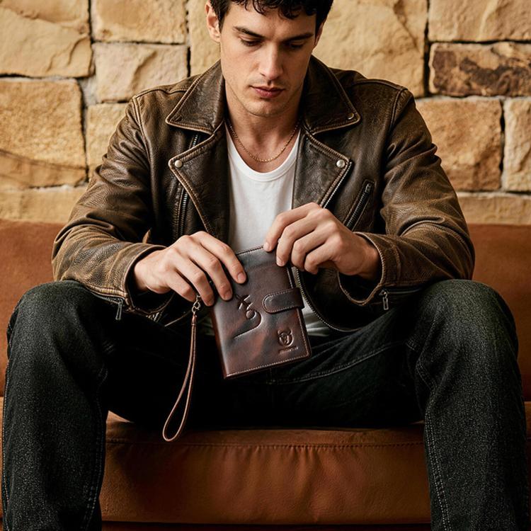 Brown leather passport holder held in hand with luggage tag and wrist strap