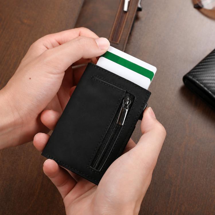 Black slim zip coin wallet held in hands, showing front card slot and zipper