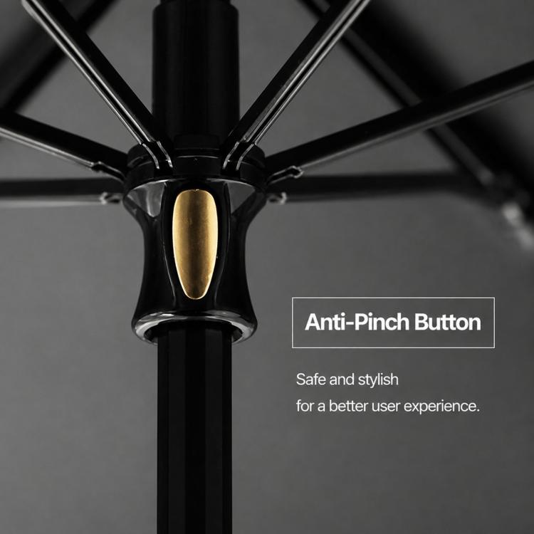 Umbrella top hub with anti-pinch button and gold-toned center, close-up