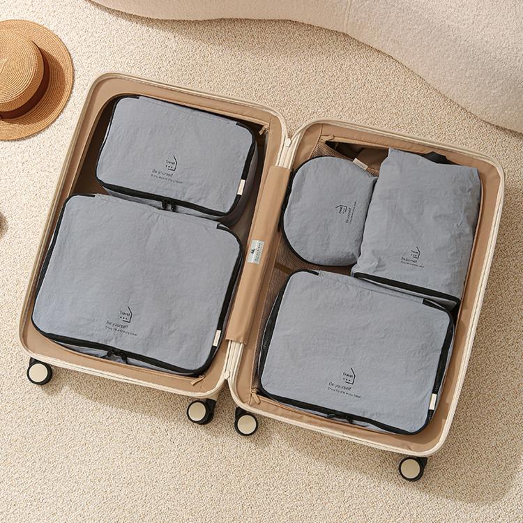 Grey-blue packing cubes set in suitcase: four zippered organizer bags