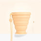 Apricot foldable silicone travel cup with lid and lanyard, shown from the side
