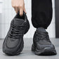 Men's grey lace-up sneakers held by heel with thick treaded sole