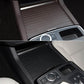 Cup holder area with black ribbed roller cover insert and control panel surround trim
