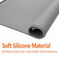 Rolled gray silicone countertop mat showing flexible thickness and curved edge