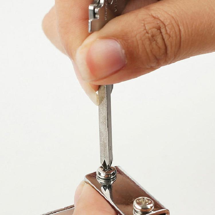 Hand holding key-shaped multitool keychain with flat-head screwdriver tip
