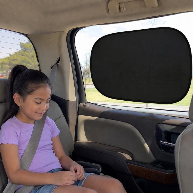 Black mesh sunshade film covering rear side window in a car