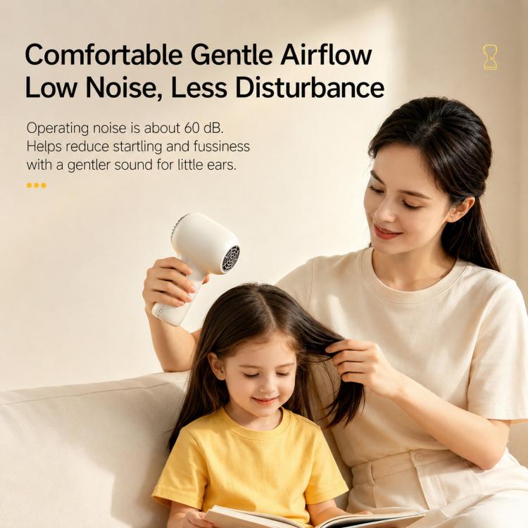 White cordless baby hair dryer held in hand with nozzle pointed forward