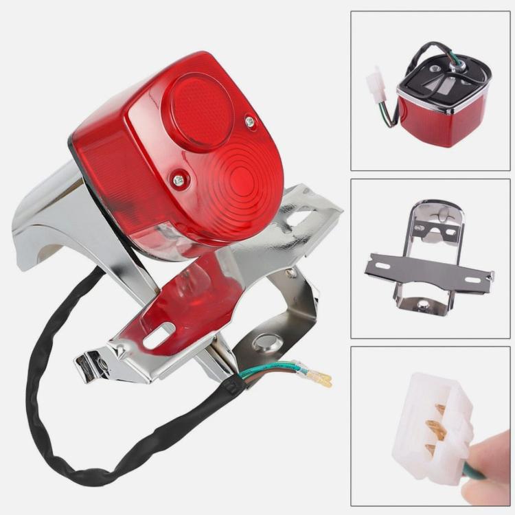 Rear tail light assembly with red lens and chrome mounting bracket, angled view