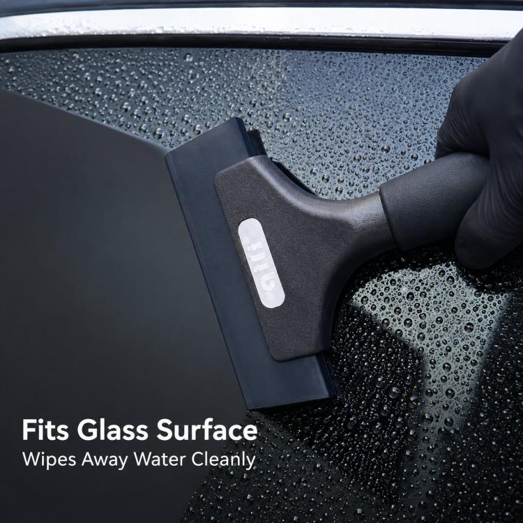 Rubber squeegee wiping water droplets from car window glass