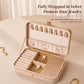 Beige velvet jewelry box with hinged lid and clasp, fully wrapped for jewelry protection