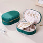 Green velvet oval jewelry case with zipper, open base trays and earring stud panel