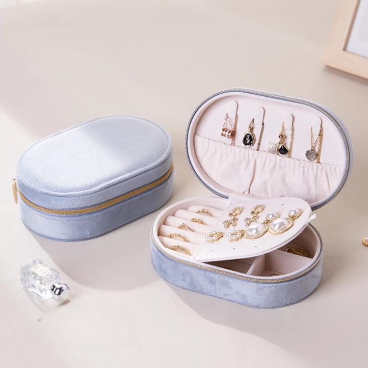 Light blue velvet oval jewelry case with zipper, open compartments and earring stud board