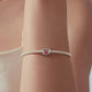 Sterling silver bracelet on wrist with small pink heart crystal bead charm
