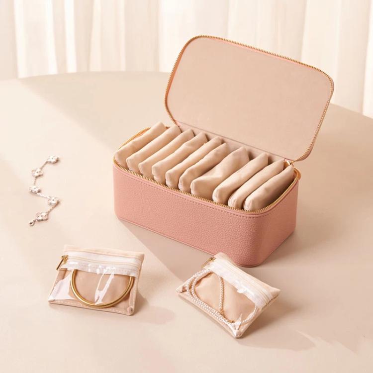 Pink PU jewelry organizer case open with 12 clear zip pouches and padded jewelry slots