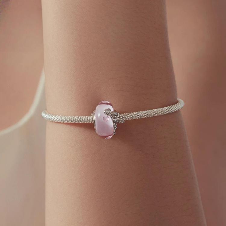 Silver bracelet with small pink glass bead charm showing an angel figure