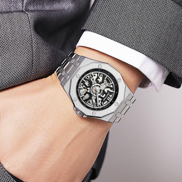 Men's skeleton automatic watch on wrist, silver case with white strap, exposed movement