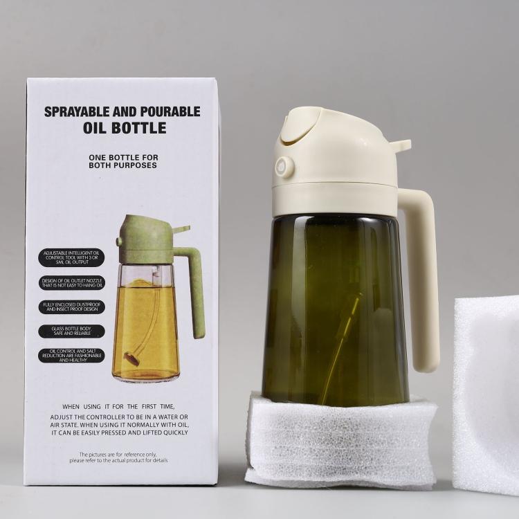 Cream white sprayer oil bottle with handle and clear glass body filled with dark oil