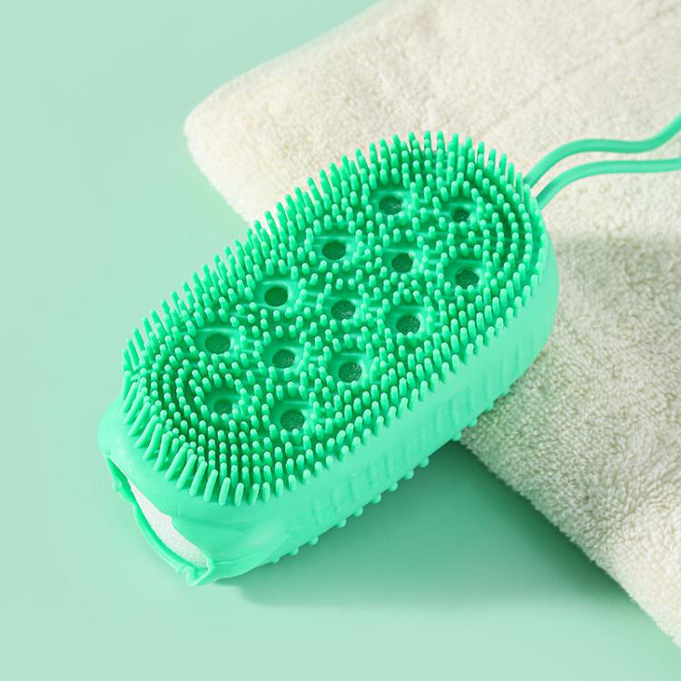 Green oval silicone body scrubber with small bristle tips on a bath sponge backing.