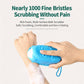Blue silicone body scrubber with bristle tips held against skin covered in rich foam.