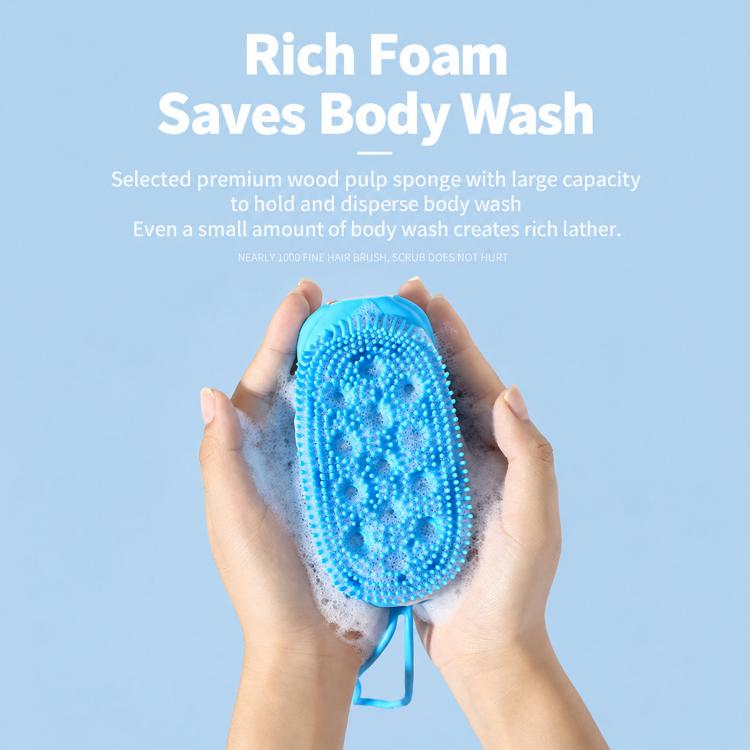 Hands holding a blue oval silicone scrubber over foam, with lanyard loop at the bottom.
