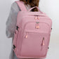 Pink travel backpack worn on shoulder with front zip compartments and top handle