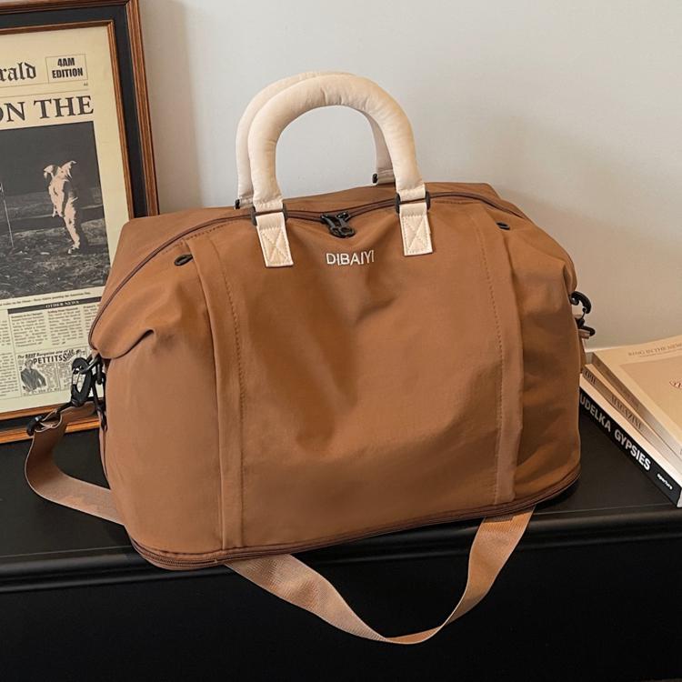 Expandable travel duffel bag in tan with cream padded handles and adjustable shoulder strap