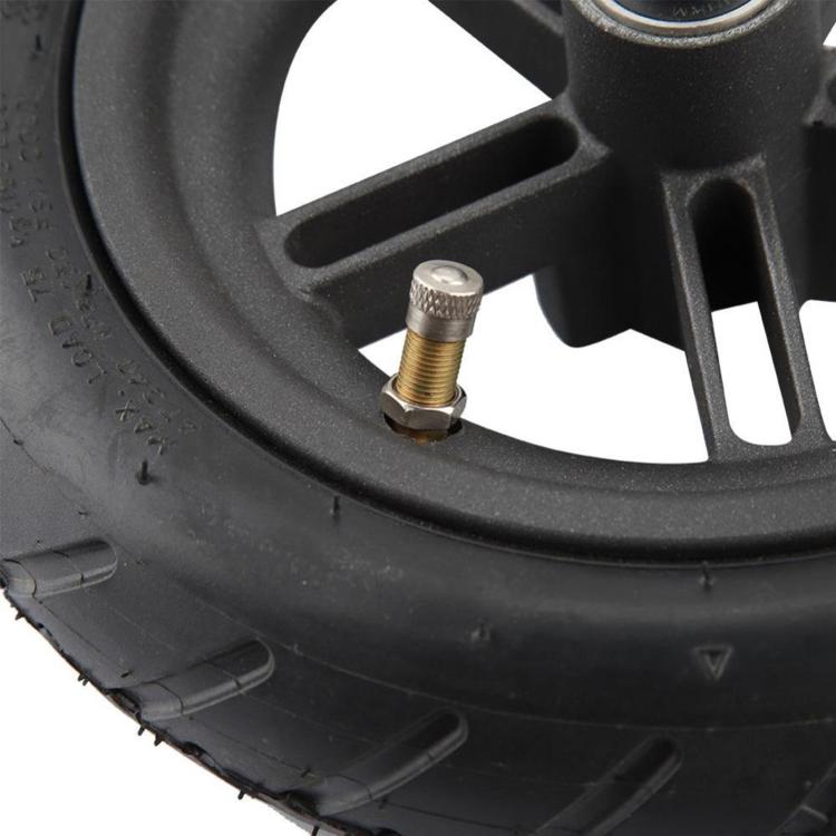 Pneumatic scooter rear wheel close-up of valve stem on black rubber tire