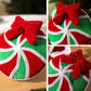 Plush hanging ornament close-up, red and green ball with silver trim and red bow