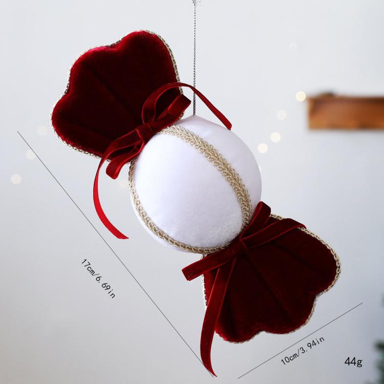 Velvet candy ornament with red scalloped ends, white oval center, gold trim and red bow